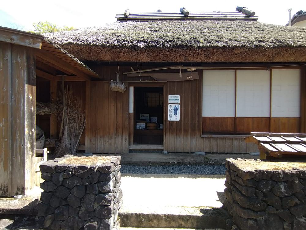 ジョン万次郎生家(復元)の正面。茅葺き屋根の木造平屋と石垣